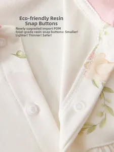 Detail of eco-friendly resin snap buttons on cotton baby romper with floral prints