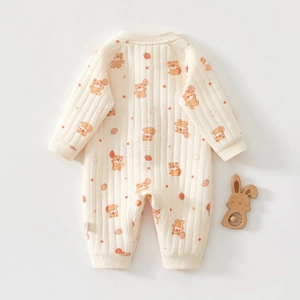Détails du tissu matelassé d'un barboteuse bébé beige avec ours et fraises imprimés