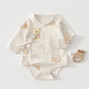 Detail of baby organic cotton bodysuit featuring side-tie design and cartoon bear prints