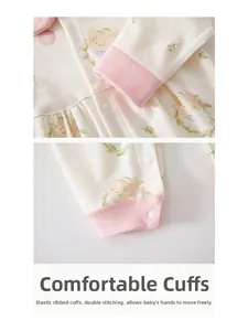 Detail of baby romper with ribbed pink cuffs and cute rabbit floral cotton fabric