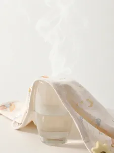 Haut bébé en coton respirant avec motifs lune et étoiles montrant la perméabilité à l'air