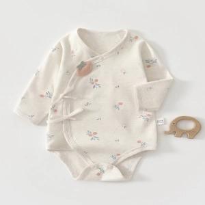 Detail of baby kimono bodysuit with peach print and 3D applique on soft organic cotton