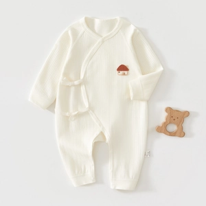 Détail du body en coton pour bébé avec texture côtelée, lien latéral et broderie maison