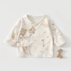 Détail d'un cache-coeur pour bébé avec motifs ours et fermeture à nouer souple