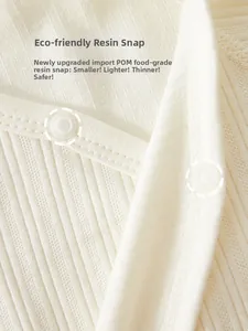 Détail des pressions en résine écologique sur le tissu côtelé du barboteuse bébé