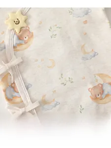Close-up of cotton baby bodysuit fabric with star, moon and bear print details