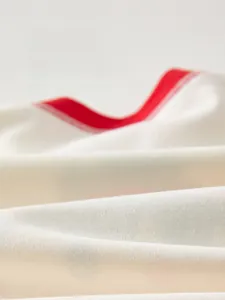 Gros plan sur la texture en coton doux et le col rouge du vêtement pour bébé