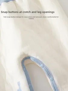 Gros plan sur le tissu matelassé de la barboteuse pour bébé avec pressions bleues