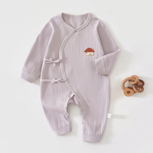 Détail d'un barboteuse bébé violet clair avec broderie maison et texture en coton côtelé