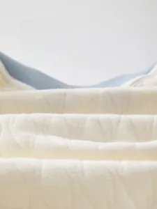 Detail of soft quilted cotton fabric with breathable texture for newborn baby clothing