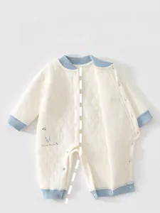 Close-up of quilted baby romper with light blue ribbed cuffs and musical note prints