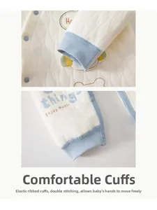 Détail d'un ensemble thermique matelassé bébé avec poignets côtelés et motifs bleus