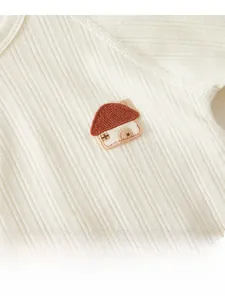 Détail du tricot en coton pour bébé avec texture douce et broderie de maison
