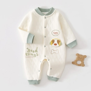 Detailed macro view of quilted cotton baby romper with dog embroidery and ribbed cuffs