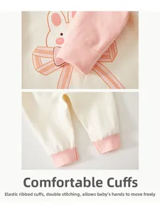 Close-up of pink ribbed cuffs and cotton fabric with cute rabbit prints on baby romper