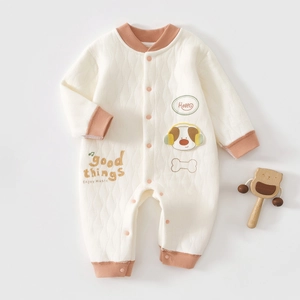 Detail of baby quilted cotton romper with dog patch and orange ribbed cuffs