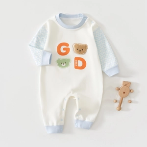 Detail of baby romper featuring blue patterned sleeves and 3D plush bear embroidery