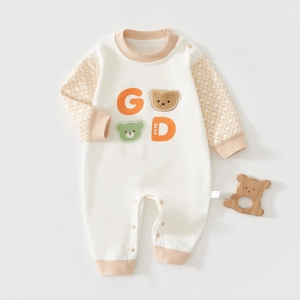 Close-up of cotton baby bodysuit featuring textured bear motif and premium snap buttons