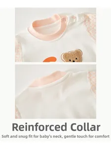 Close-up of baby romper collar with pink ribbed edging and snap button detail