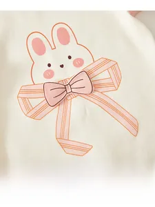 Close-up of baby romper featuring a cute pink rabbit print and 3D striped bow detail