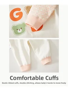 Detail of ribbed cuffs and stitching on baby romper with cute bear and letter print