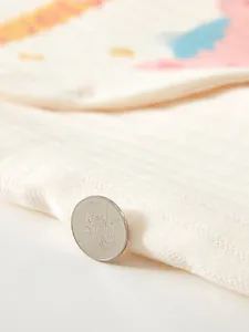 Close-up of soft cream padded cotton fabric texture with warm knit pattern for baby clothes