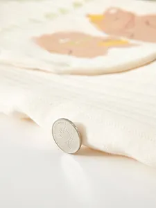 Detailed macro view showing thick white quilted cotton fabric with a cute bear pattern
