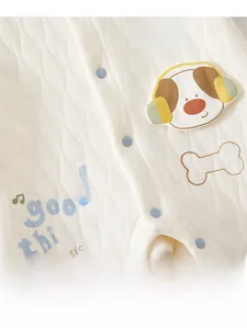 Detail of baby quilted cotton romper showing blue snap buttons and dog embroidery