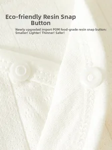 Detail of eco-friendly resin snap fasteners on soft white cotton newborn baby clothing