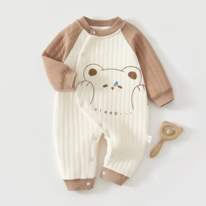Close-up of baby romper showing quilted fabric texture and cute cartoon bear pattern