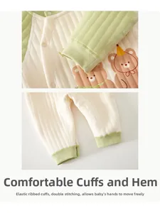 Detail view of elastic ribbed cuffs and quilted fabric on infant winter bodysuit with bear print
