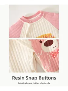 Detail view of pink quilted baby bodysuit showing secure resin snaps and waffle texture