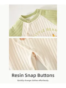Detail view of resin snap buttons and quilted warm fabric on infant jumpsuit