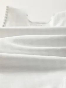 Gros plan sur le tissu en coton blanc doux et respirant pour costume bébé automne