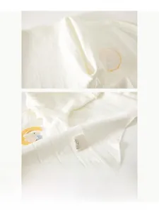 Macro detail of seamless stitching and bunny moon embroidery on cotton baby bodysuit