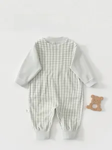 Détail du dos d'un body pour bébé avec motif vichy vert et texture en coton doux