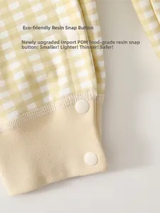 Detail of yellow gingham baby romper featuring safe food-grade resin snap buttons