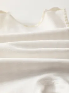 Macro detail of breathable knit fabric and fine stitching for baby cotton overalls