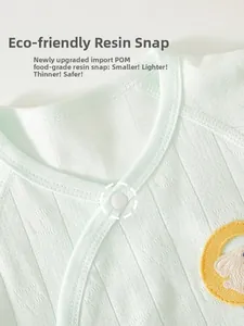 Detail of soft green ribbed cotton baby top with eco-friendly resin snap and animal patch