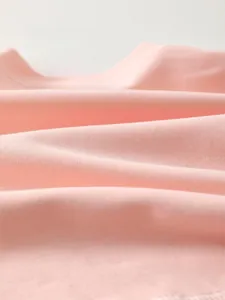Close-up of soft pink baby knit fabric showing fine texture and breathable cotton fibers