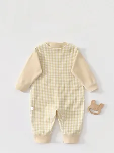 Detail view of baby yellow checkered romper with soft ribbed cuffs and cute wooden bunny toy