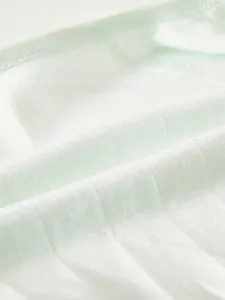 Close-up of light green vertical ribbed knit fabric with soft breathable texture for babies