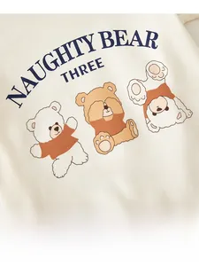Détail de la barboteuse pour bébé avec imprimé ours sur tricot doux de couleur crème