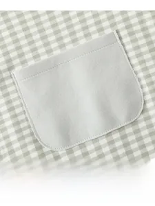 Détail de la salopette pour bébé en coton à carreaux verts avec poche fonctionnelle