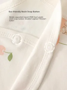 Detail of baby romper with eco-friendly resin snap buttons and soft peach print fabric