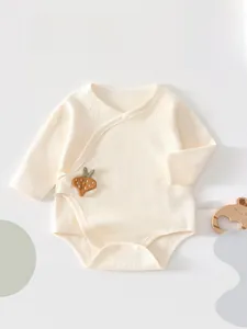 Detail of baby cotton bodysuit with carrot embroidery and side snap buttons