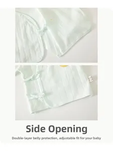Detail of light green cotton baby kimono top with side ties and sun embroidery