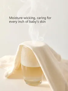 Breathable white cotton newborn romper showing moisture-wicking properties and soft texture
