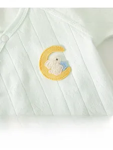 Close-up of baby clothing featuring green jacquard fabric and moon rabbit embroidery