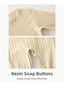 Detail of yellow baby jumpsuit showing resin snaps on shoulder and crotch for easy diapering